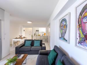 a living room with two couches and a table at Mackenzie Leo Seafront Suite in Larnaka +19 photos