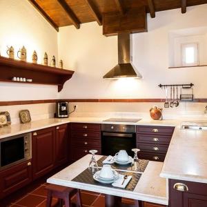 a kitchen with wooden cabinets and a stove top oven at Hotel Rural Monte da Provença in Elvas