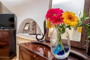 un jarrón con flores en una mesa en una habitación en Il Nido Casa Vacanze, en Atrani