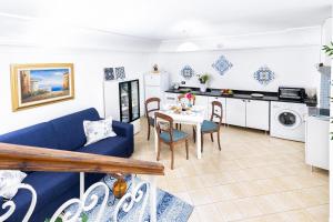 a living room with a blue couch and a table at Il Nido Casa Vacanze in Atrani +16 photos