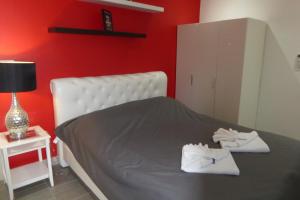 Tropicana Beach Villa at VIP Resort في بان فيه: غرفة نوم حمراء عليها سرير وفوط