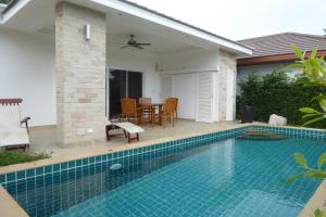 a swimming pool in front of a house at Tropicana Beach Villa at VIP Resort in Ban Phe