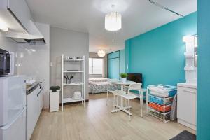 松戶的住宿－松戸 テイクファイブ - 水色1DK Nomad松戸宿015，厨房配有桌子和蓝色的墙壁