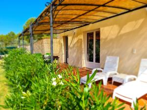 d'une terrasse avec des chaises blanches et une pergola. dans l'établissement Villa Lavanda, à Trans-en-Provence