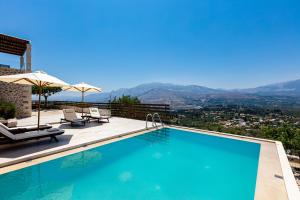 a swimming pool with a view of the mountains at Villa Galanis in Kalamitsi Amygdali