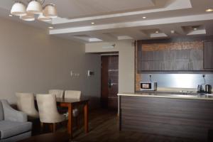 uma sala de estar com uma cozinha e uma mesa e cadeiras em Dar Telal Hotel suites em Abha