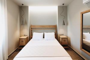a bedroom with a large bed with two night stands at Costa D' Ifesto in Agios Ioannis Kaspaka