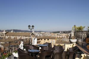 eine Terrasse mit Stühlen und Tischen auf dem Balkon in der Unterkunft Hotel Pace Helvezia in Rom
