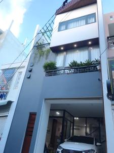 a car parked in front of a white building at Triple-T Homestay in Vung Tau