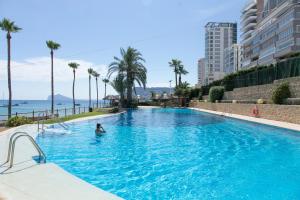 a person in a swimming pool with the ocean in the background at Sotavento Atico Calpe in Calpe