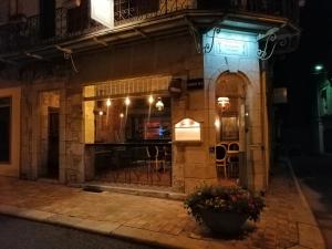 un negozio di fronte a un edificio di notte di L'Entrée Chambres d'Hôtes Bar & Restaurant a Castillonnès