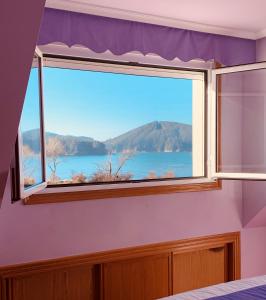 1 dormitorio con ventana y vistas al lago en Ático en primera línea de playa en Cedeira