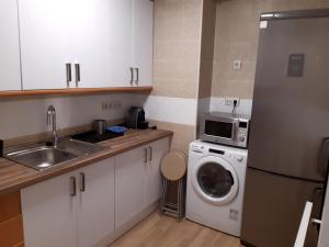 uma cozinha com uma máquina de lavar roupa e um micro-ondas em Apartamento junto a la Catedral 2 dormitorios em Almeria