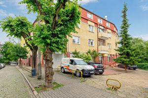 a yellow bench on a sidewalk next to a building at Grand Apartments - Studio Apartment 50 m from Monte Cassino in Sopot