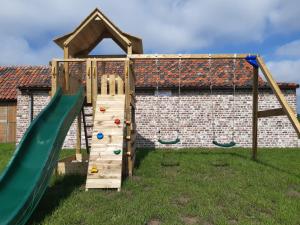 a wooden playground with a slide and swings at Hauwaertshoeve in Beernem