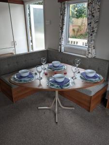 a table with plates and wine glasses on a couch at Hastings- Coghurst Hall park in Ore