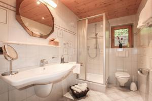 a bathroom with a sink and a shower and a toilet at Hotel Pension Hubertus in Bad Reichenhall