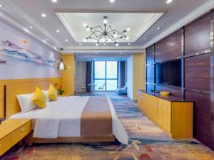 - une chambre avec un grand lit et une télévision à écran plat dans l'établissement Chongqing Ouranjian Lake View Guesthouse, à Chongqing