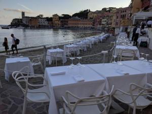 a row of white tables and chairs on a beach at Hotel Miramare & Spa in Sestri Levante