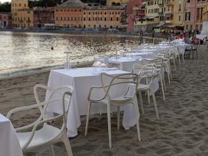 a row of tables and chairs on a sandy beach at Hotel Miramare & Spa in Sestri Levante