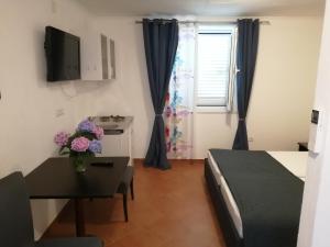salon z łóżkiem, stołem i oknem w obiekcie Viola rooms w mieście Gruda