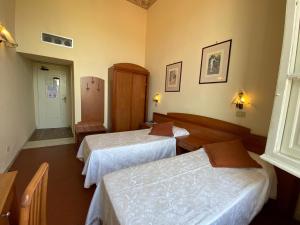 een hotelkamer met 2 bedden en een hal bij Hotel Italia in Marina di Massa