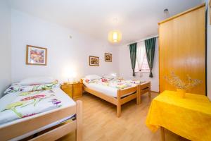 a bedroom with two beds and a table in it at Apartment Marko in Kornić