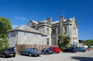 an old house with cars parked in front of it at Hastings- Coghurst Hall park in Ore