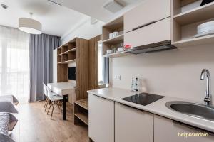 a kitchen with a sink and a desk in a room at Apartament w Warszawie dedykowany parking podziemny w cenie, WiFi, blisko centrum New apartment in Warsaw finished to a high specification fitted out to a high standard on the 7th floor, WiFi, underground parking price included in Warsaw