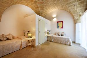 a bedroom with two beds and a brick wall at Masseria San Rocco in Gallipoli