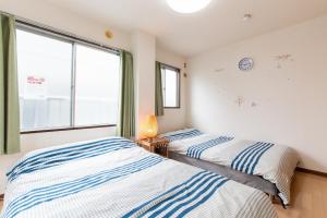 松戶的住宿－松戸 テイクファイブ 1DK Nomad松戸宿056，带窗户的客房内的两张床