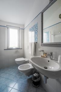 a white bathroom with a sink and a toilet at La corte dei tre in Torre del Lago Puccini