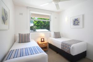a hotel room with a bed and a window at Maison Noosa in Noosa Heads