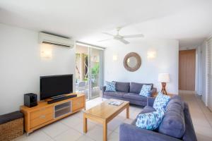 a living room filled with furniture and a tv at Maison Noosa in Noosa Heads