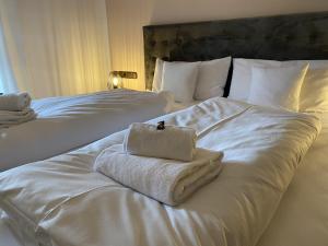 een hotelkamer met twee bedden met witte handdoeken erop bij Apartment SEEnsucht - Tolle Lage, nah am See, perfekt für Familien in Schliersee