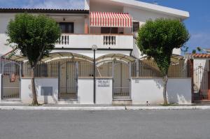 two trees in front of a building with a gate at Villa Angela in Scalea