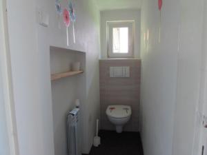 a small bathroom with a toilet and a window at Dům u rybníka in Nýdek