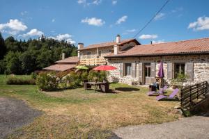 Casa con patio con sillas y sombrilla en Moulin des Comtes - Gite des Graines, en Viverols