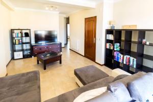 uma sala de estar com um sofá e uma televisão em Guest House 4U - Povoa seaside na Póvoa do Varzim