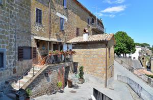 a brick building with potted plants on a balcony at Le Calanque La Terrazza su Civita in Lubriano