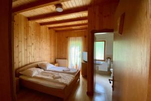 1 dormitorio con 1 cama en una habitación de madera en Platán Vendégház, en Izvoare
