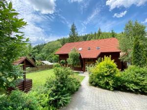 ein Haus mit einem roten Dach und einem Garten in der Unterkunft Platán Vendégház in Izvoare