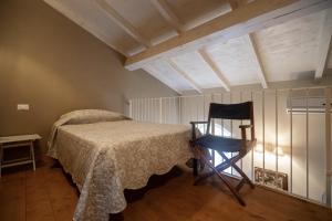a bedroom with a bed and a chair in it at La corte dei tre in Torre del Lago Puccini