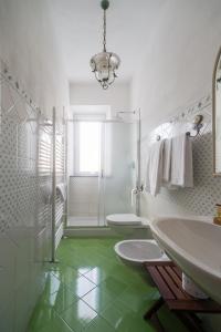 - une salle de bains blanche avec deux lavabos et une douche dans l'établissement La corte dei tre, à Torre del Lago Puccini