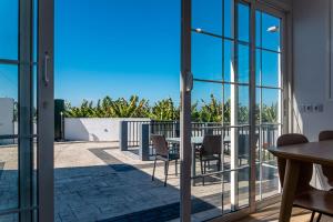 balkon ze szklanymi drzwiami oraz stołem i krzesłami w obiekcie Villa Kabanita w mieście Tazacorte