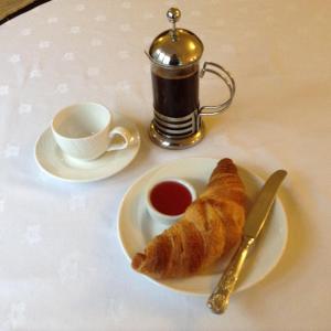 un plato con un cruasán y una taza de té en East Cliff Cottage Hotel, en Bournemouth