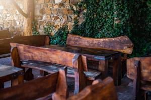 a wooden table and chairs in front of a stone wall at U Matyase in Stod