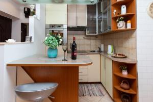 a small kitchen with a table with a bottle of wine and a glass at Studio Ami in Zagreb