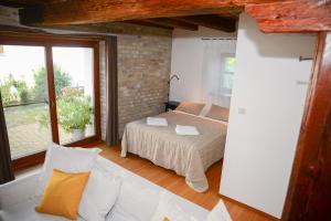 een slaapkamer met een bed en een bakstenen muur bij Somos Apartman in Győr