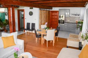 a dining room and living room with a table and chairs at Somos Apartman in Győr